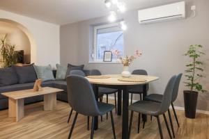 a living room with a table and chairs and a couch at Lazar Apartman in Čantavir