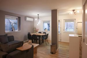 a living room and kitchen with a table and a couch at Lazar Apartman in Čantavir