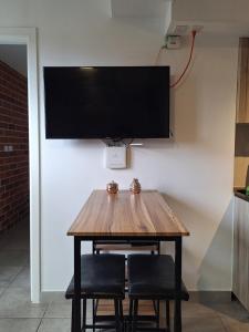 a wooden table with two chairs and a television on a wall at Flamingo zona 4 in Guatemala