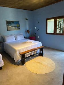 a bedroom with a large bed and a window at Odoyá Corumbau in Corumbau