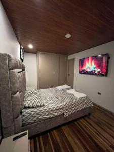 a bedroom with a bed with a tv on the wall at Apto Domus in Pamplona