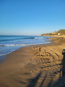 a beach with footprints in the sand and the ocean at Dragonfly in Treasure Beach +8 photos