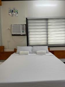 a bedroom with a large bed with two towels on it at Chia's Beach House Siargao in Cabalawan