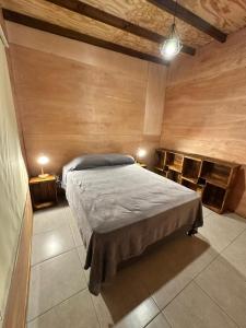 a bedroom with a bed in a room with wooden walls at Refugio del Mar 3 in Ocean Park