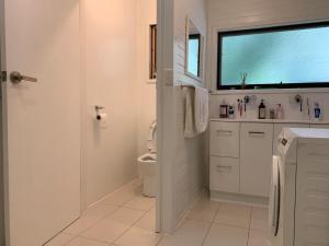 a white bathroom with a toilet and a window at Retreat in a beautiful forest! in McMahons Creek +51 photos