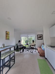two people sitting at tables in a living room at Casa del Bosque in Suesca