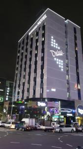 un gran edificio con coches estacionados frente a él en Dubai Hotel, en Gwangju