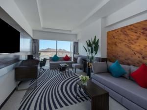 un soggiorno con divano e TV a schermo piatto di Novotel Makkah Thakher City a La Mecca
