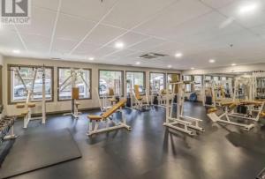 a gym with several treadmills and exercise equipment at Oceanside Getaway in Nanoose Bay