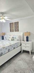 a white bedroom with a bed and a night stand at Beach Condo in Clearwater Beach +67 photos