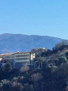 a large building on a hill with a mountain in the background at La Terrazza Apartment in Cosenza