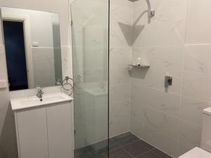 a bathroom with a shower with a sink and a toilet at Commercial Hotel Parkes in Parkes