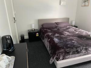 a bedroom with a bed and a table with a tv at Commercial Hotel Parkes in Parkes