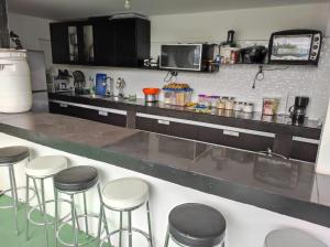 a kitchen with a counter with stools in it at Finca Villa Lake in Horizonte