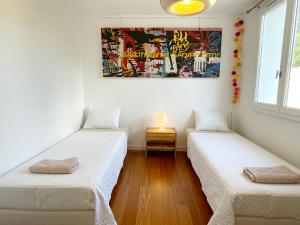 two beds in a room with a painting on the wall at Art_Booking . . . by Benoit_B in Duingt