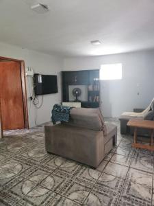 a living room with a couch and a tv at casa aconchegante para descansar in Alegrete