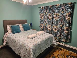 a bedroom with a bed with a blanket and a curtain at Moredon Bungalow in Swindon