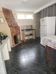 a kitchen with a white refrigerator and a fireplace at casa aconchegante para descansar in Alegrete