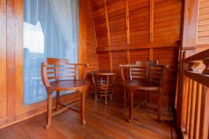 a room with three chairs and a window at Villa Kartikasari in Munduk