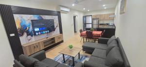 a living room with a couch and a tv and a table at The Retreat Apartment in Nadi