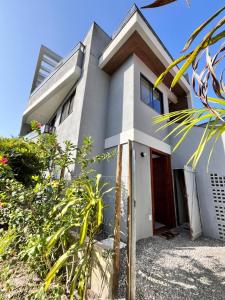 a white house with a red door and some plants at Casa Liz in Itacaré