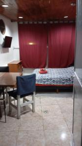 a room with a bed and a desk and a table at Che Lolita house 4 in Buenos Aires +3 photos