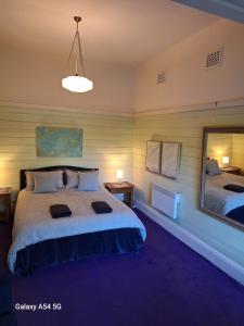 a bedroom with a large bed and a mirror at The Gables - Circa 1880 - Classic Bowral Property in Bowral