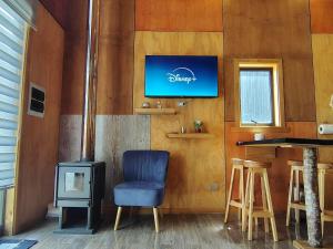 a living room with a blue chair and a stove at Cabaña Valdivia in Valdivia