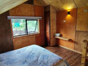 a bedroom with a bed and a window at Cabaña Valdivia in Valdivia