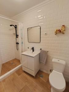 a white bathroom with a toilet and a sink at Casa do Ferro de Engomar in Samouco