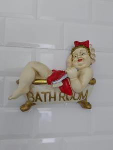 a statue of a man laying on a bathroom sign at Casa do Ferro de Engomar in Samouco