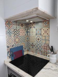 a kitchen with a counter with tiles on the wall at Casa do Ferro de Engomar in Samouco