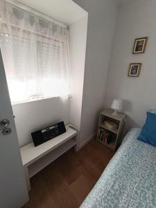 a small bedroom with a bed and a window at Casa do Ferro de Engomar in Samouco +16 photos