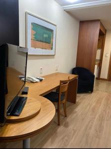 a wooden desk with a computer on top of it at Lindo flat Grand Mercoure triplo in Brasília