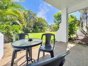a table and chairs sitting on a patio at Poolside Mango House in Airlie Beach +45 photos