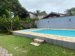 a swimming pool in the backyard of a house at Casa com 2 Piscinas infantil e adulto a 450m da Praia Até 15 Pessoas in São Sebastião