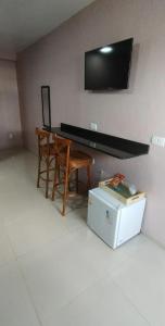 a room with a table and a chair and a television at Pousada Santa Maria in Canoinhas