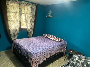 a blue bedroom with a bed and a window at Casa com 2 Piscinas infantil e adulto a 450m da Praia Até 15 Pessoas in São Sebastião +31 photos