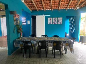 a table and chairs in a room with a blue wall at Casa com 2 Piscinas infantil e adulto a 450m da Praia Até 15 Pessoas in São Sebastião