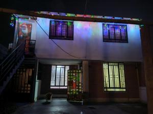 a building with stained glass windows and stairs at night at Casita de camucha segundo piso in Chincha Baja
