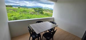 a table and chairs in a room with a large window at The Retreat Apartment in Nadi