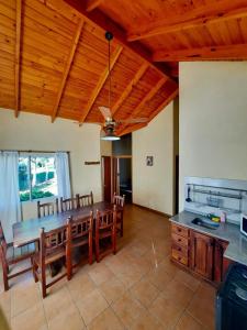 a dining room with a table and wooden ceilings at Balcón del Cerro Cabañas in La Falda