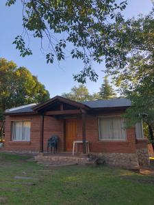 a small brick house with a chair in front of it at Balcón del Cerro Cabañas in La Falda