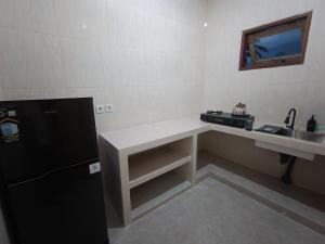 a kitchen with a counter and a sink and a refrigerator at Dharma Yoga Guest House Amed in Amed +14 photos