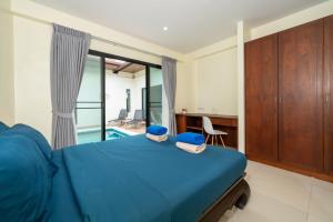 a bedroom with a bed and a desk and a pool at Rawai - 3 BR Private Pool Villa - Phoomjai Villa in Rawai Beach +47 photos