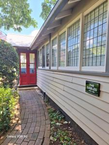 a house with a red door and a sign on it at The Gables - Circa 1880 - Classic Bowral Property in Bowral