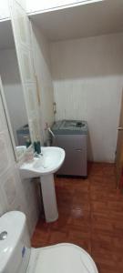 a bathroom with a white sink and a toilet at Cabaña Quiroz in Valdivia