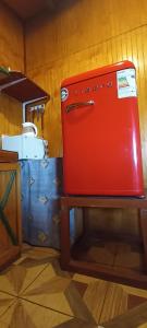 a red refrigerator sitting on top of a table at Cabaña Quiroz in Valdivia +3 photos