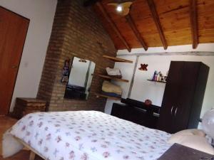 a bedroom with a bed and a brick wall at Claro de Luna in Los Reartes +5 photos