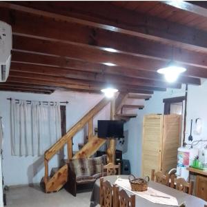 a living room with wooden ceilings and a staircase at Claro de Luna in Los Reartes